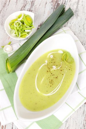 Delicious leek soup in white bowl with fresh and cut leek on white wooden background. Culinary healthy eating, top view. Stock Photo - Budget Royalty-Free & Subscription, Code: 400-07745947