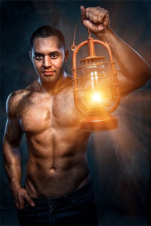 Muscular build man holding oil lamp Fotografie stock - Microstock e Abbonamento, Codice: 400-07747005