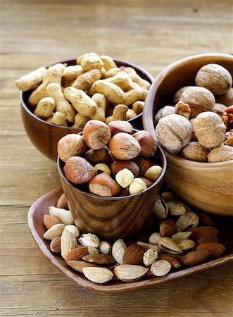 simsearch:400-07310170,k - different kinds of nuts (almonds, walnuts, hazelnuts, peanuts) in a bowl on a wooden table Fotografie stock - Microstock e Abbonamento, Codice: 400-07747732