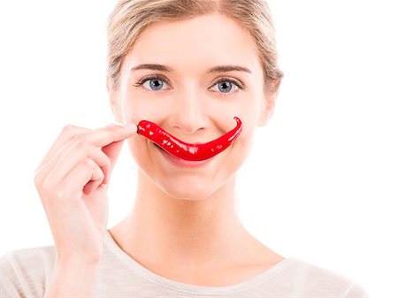 simsearch:400-07899696,k - Beautiful girl making a smile with a red chilli pepper in front of the mouth, isolated over white background Photographie de stock - Aubaine LD & Abonnement, Code: 400-07747916