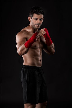 simsearch:400-04014026,k - Portrait of a muscular man practicing body combat against a dark background Fotografie stock - Microstock e Abbonamento, Codice: 400-07747980