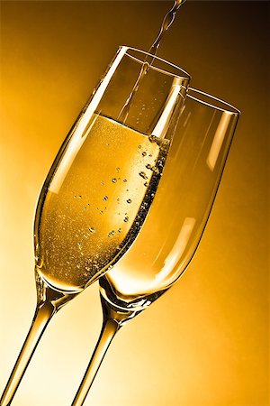 empty glasses of champagne and one being filled against golden background Stock Photo - Budget Royalty-Free & Subscription, Code: 400-07748192
