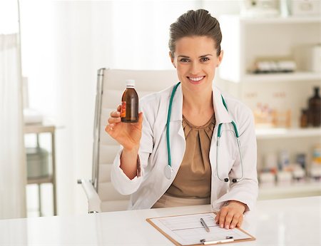 simsearch:400-07099882,k - Smiling doctor woman showing medicine bottle Photographie de stock - Aubaine LD & Abonnement, Code: 400-07748387