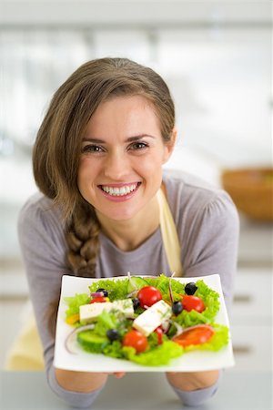 Portrait of smiling young housewife showing greek salad Stock Photo - Budget Royalty-Free & Subscription, Code: 400-07748420