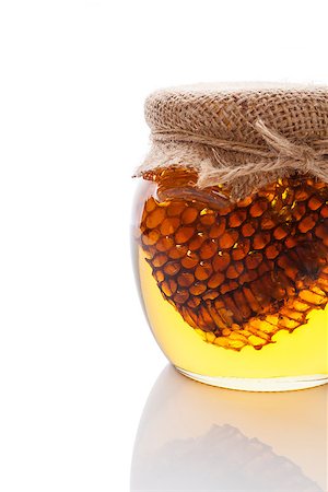 Organic honey with honey comb in glass jar isolated on white. Natural healthy sweetener. Photographie de stock - Aubaine LD & Abonnement, Code: 400-07749458
