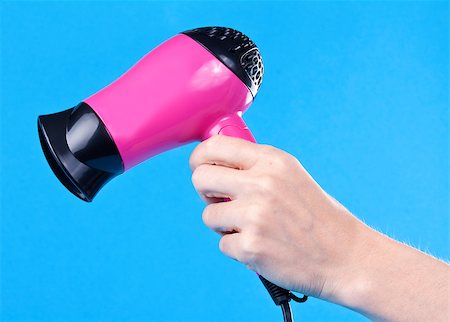 Pink hair dryer in the female hand on a blue background Stock Photo - Budget Royalty-Free & Subscription, Code: 400-07754664