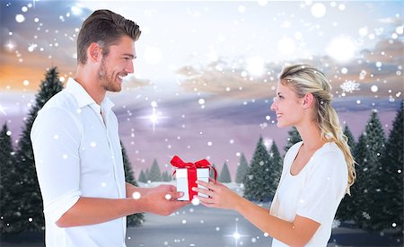 simsearch:400-07755560,k - Young couple with gift against snowy landscape with fir trees Stock Photo - Budget Royalty-Free & Subscription, Code: 400-07755375