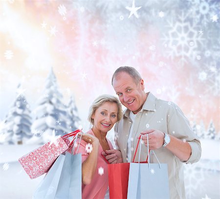 simsearch:400-07755560,k - Couple with shopping bags against snowy landscape with fir trees Stock Photo - Budget Royalty-Free & Subscription, Code: 400-07755413