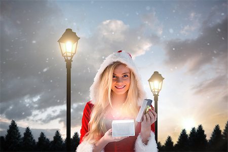 simsearch:400-07755560,k - Sexy santa girl opening gift against lampposts at night Stock Photo - Budget Royalty-Free & Subscription, Code: 400-07755431