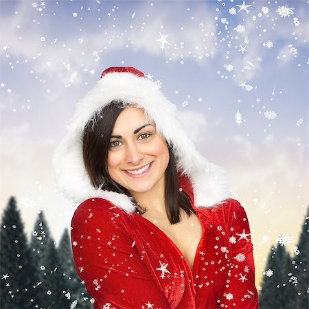 simsearch:400-07755560,k - Pretty girl smiling in santa outfit against snowy landscape with fir trees Stock Photo - Budget Royalty-Free & Subscription, Code: 400-07755525