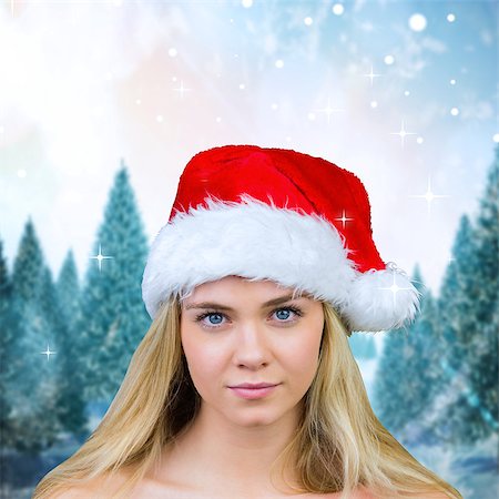 simsearch:400-07755560,k - Blonde with bare shoulders in santa hat against snowy landscape with fir trees Stock Photo - Budget Royalty-Free & Subscription, Code: 400-07755540