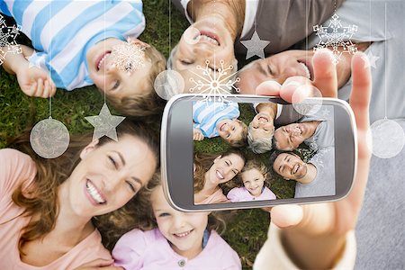 senior hand and smartphone - Hand holding smartphone showing extended family lying in circle at park Stock Photo - Budget Royalty-Free & Subscription, Code: 400-07755635