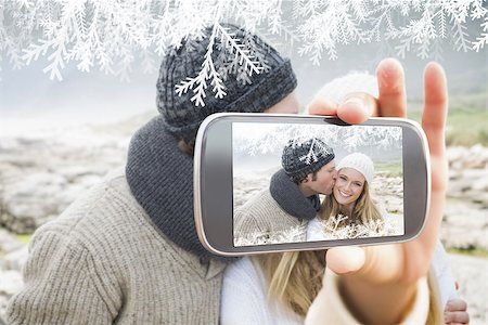simsearch:400-07664794,k - Hand holding smartphone showing man kissing a woman on rocky landscape Stock Photo - Budget Royalty-Free & Subscription, Code: 400-07755632
