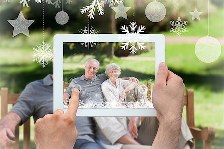 simsearch:400-07664794,k - Hands holding tablet pc against senior couple sitting on a bench Stock Photo - Budget Royalty-Free & Subscription, Code: 400-07755646