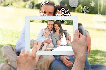 family with tablet in the park - Hands holding tablet pc against family sitting in the park Stock Photo - Budget Royalty-Free & Subscription, Code: 400-07755643
