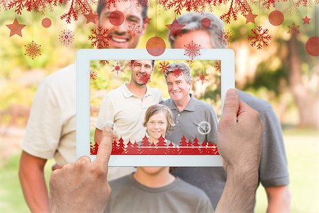 family with tablet in the park - Hands holding tablet pc against family looking at the camera in the park Stock Photo - Budget Royalty-Free & Subscription, Code: 400-07755654