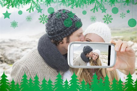 simsearch:400-07664794,k - Hand holding smartphone showing man kissing a woman on rocky landscape Stock Photo - Budget Royalty-Free & Subscription, Code: 400-07755673