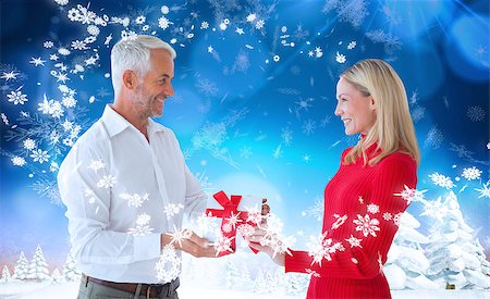 simsearch:400-07755560,k - Loving couple with gift against snowy landscape with fir trees Stock Photo - Budget Royalty-Free & Subscription, Code: 400-07755710