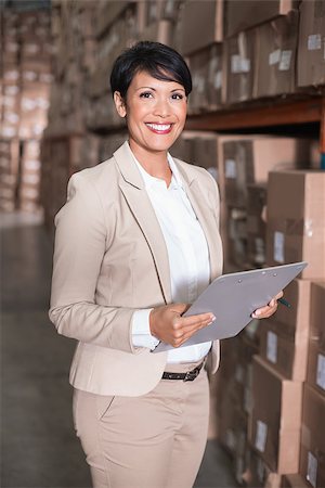 simsearch:6109-08581643,k - Pretty warehouse manager smiling at camera in a large warehouse Stockbilder - Microstock & Abonnement, Bildnummer: 400-07750147