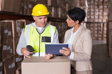 Warehouse worker scanning box with manager in a large warehouse Stock Photo - Budget Royalty-Free & Subscription, Code: 400-07750185