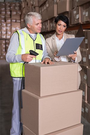 Warehouse worker scanning box with manager in a large warehouse Stock Photo - Budget Royalty-Free & Subscription, Code: 400-07750183