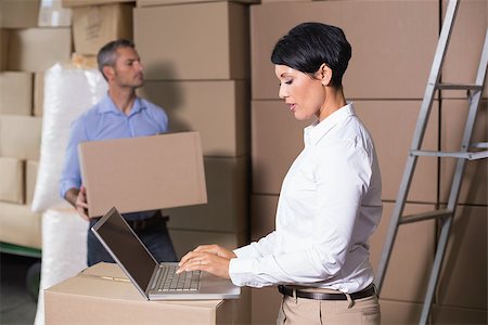 simsearch:400-07750413,k - Pretty warehouse manager using laptop in a large warehouse Photographie de stock - Aubaine LD & Abonnement, Code: 400-07750227