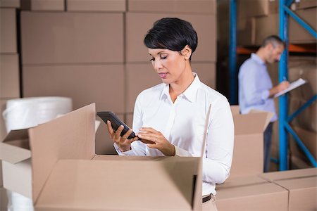 simsearch:400-07750413,k - Pretty warehouse manager using calculator in a large warehouse Photographie de stock - Aubaine LD & Abonnement, Code: 400-07750247