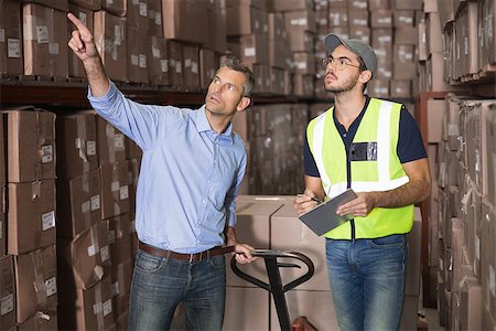 Warehouse manager talking with worker in a large warehouse Stock Photo - Budget Royalty-Free & Subscription, Code: 400-07750373