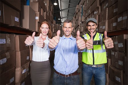simsearch:400-07750413,k - Warehouse team smiling at camera showing thumbs up in a large warehouse Photographie de stock - Aubaine LD & Abonnement, Code: 400-07750389