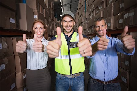 simsearch:400-07750413,k - Warehouse team smiling at camera showing thumbs up in a large warehouse Photographie de stock - Aubaine LD & Abonnement, Code: 400-07750390