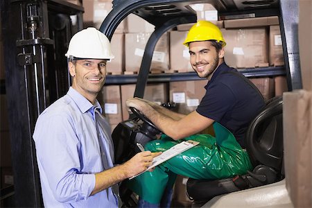 simsearch:400-07750413,k - Warehouse manager talking with forklift driver in a large warehouse Photographie de stock - Aubaine LD & Abonnement, Code: 400-07750429