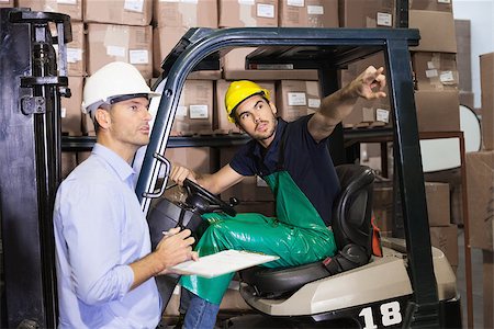 simsearch:400-07750413,k - Warehouse manager talking with forklift driver in a large warehouse Photographie de stock - Aubaine LD & Abonnement, Code: 400-07750431