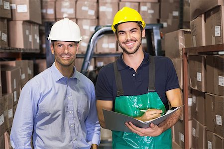 simsearch:400-07750413,k - Warehouse manager and foreman smiling at camera in a large warehouse Photographie de stock - Aubaine LD & Abonnement, Code: 400-07750433