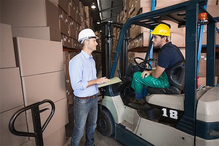 simsearch:400-08260997,k - Warehouse manager talking with forklift driver in a large warehouse Fotografie stock - Microstock e Abbonamento, Codice: 400-07750456