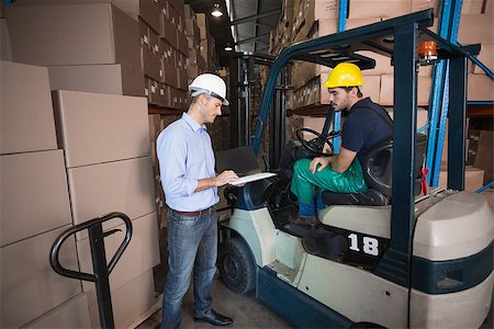 simsearch:400-08260997,k - Warehouse manager talking with forklift driver in a large warehouse Fotografie stock - Microstock e Abbonamento, Codice: 400-07750457