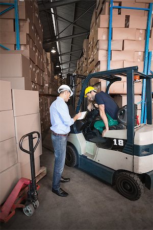 simsearch:400-08260997,k - Warehouse manager talking with forklift driver in a large warehouse Fotografie stock - Microstock e Abbonamento, Codice: 400-07750460