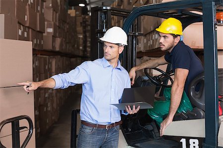 simsearch:400-08260997,k - Warehouse manager talking with forklift driver in a large warehouse Fotografie stock - Microstock e Abbonamento, Codice: 400-07750463