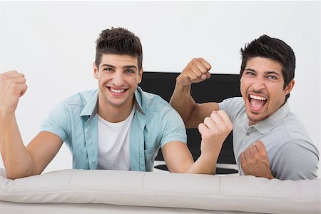 sports fan watching a game on tv - Portrait of two excited soccer fans watching tv Stock Photo - Budget Royalty-Free & Subscription, Code: 400-07750628