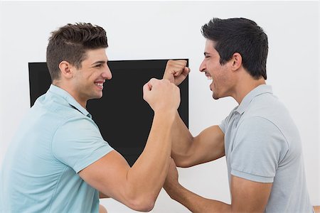 sports fan watching a game on tv - Side view of two excited soccer fans watching tv Stock Photo - Budget Royalty-Free & Subscription, Code: 400-07750631