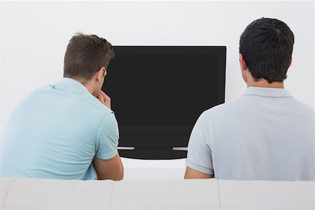 sports fan watching a game on tv - Rear view of two soccer fans watching tv Stock Photo - Budget Royalty-Free & Subscription, Code: 400-07750632