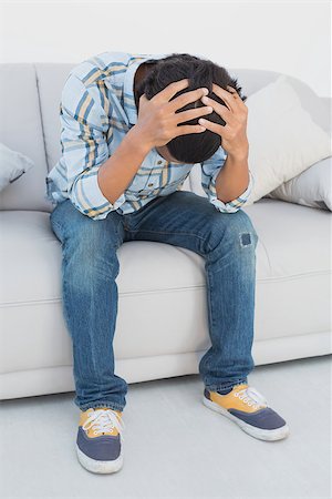 sports spectator sofa - Tensed football fan sitting on couch with head in hands Stock Photo - Budget Royalty-Free & Subscription, Code: 400-07750711