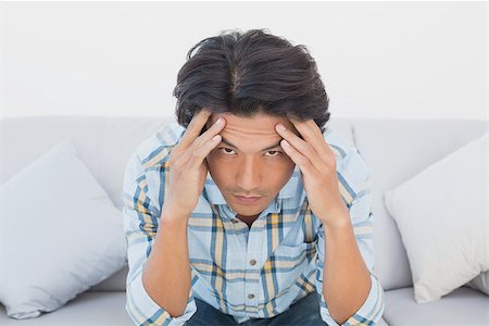 Tensed football fan sitting on couch with head in hands Stock Photo - Budget Royalty-Free & Subscription, Code: 400-07750712