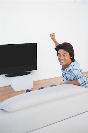 sports fan watching a game on tv - Portrait of a soccer fan cheering while watching tv Stock Photo - Budget Royalty-Free & Subscription, Code: 400-07750808