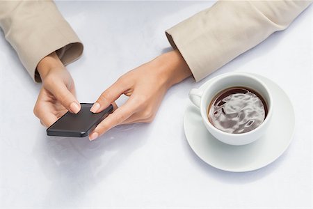 Businesswoman using smartphone with coffee outside at the coffee shop Stock Photo - Budget Royalty-Free & Subscription, Code: 400-07751275