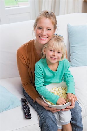 simsearch:400-05897773,k - Happy mother and daughter watching tv at home in the living room Stock Photo - Budget Royalty-Free & Subscription, Code: 400-07751546