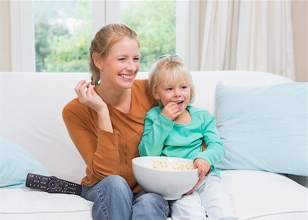 simsearch:400-05897773,k - Happy mother and daughter watching tv at home in the living room Stock Photo - Budget Royalty-Free & Subscription, Code: 400-07751548