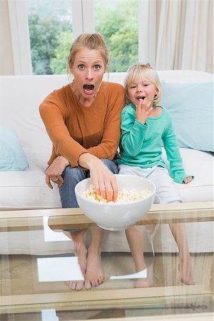 simsearch:400-05897773,k - Happy mother and daughter watching tv at home in the living room Stock Photo - Budget Royalty-Free & Subscription, Code: 400-07751549