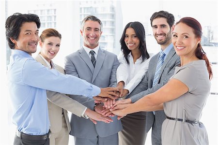 pile hands bussiness - Business team stacking their hands together while smiling Stock Photo - Budget Royalty-Free & Subscription, Code: 400-07751841