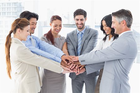 pile hands bussiness - Business team stacking their hands together while smiling Stock Photo - Budget Royalty-Free & Subscription, Code: 400-07751842