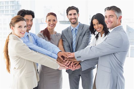 pile hands bussiness - Business team stacking their hands together while smiling Stock Photo - Budget Royalty-Free & Subscription, Code: 400-07751843